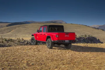 Jeep Gladiator mostrando su perfil lateral en terreno rugoso.