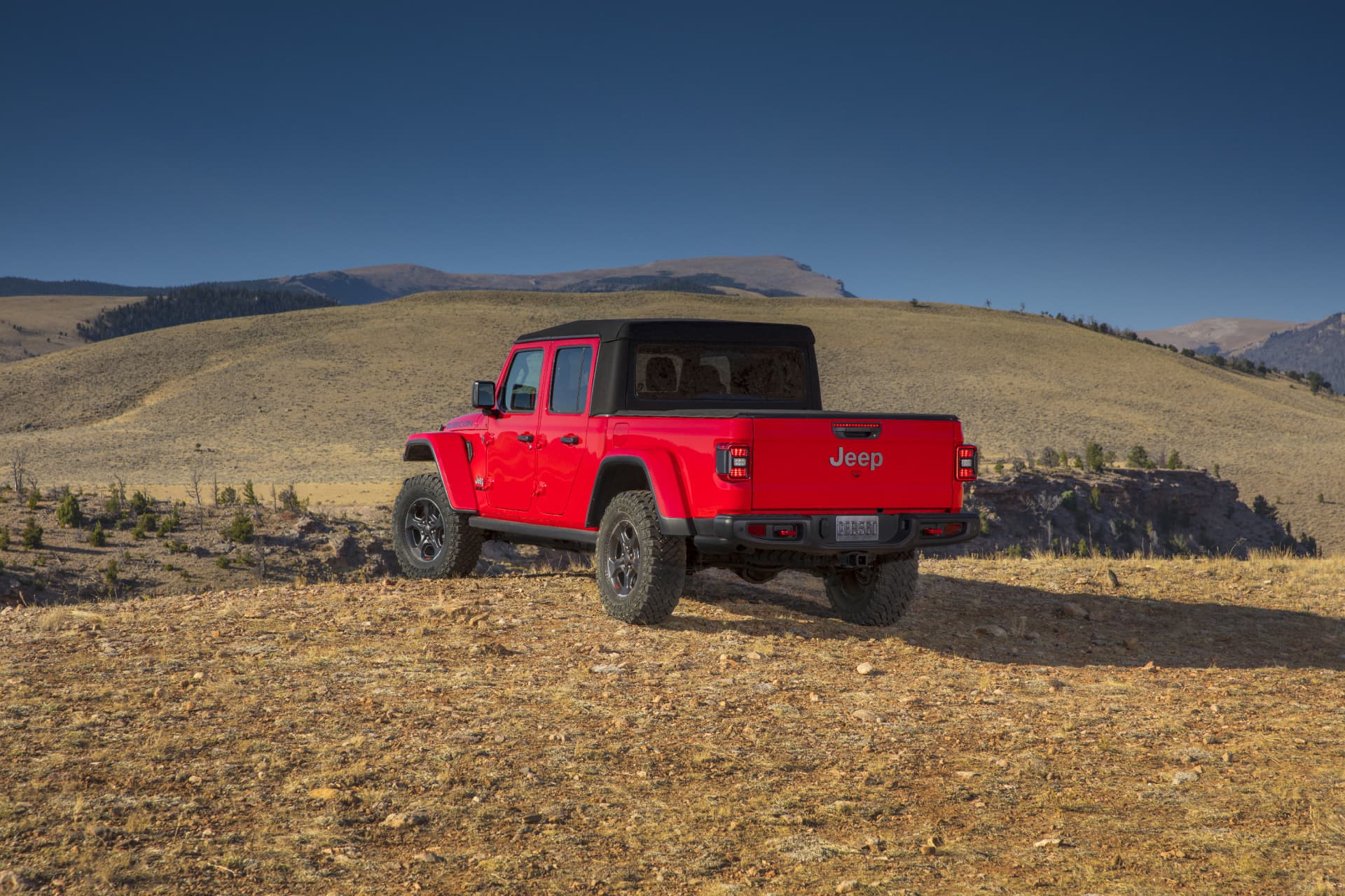 Jeep Gladiator mostrando su perfil lateral en terreno rugoso.