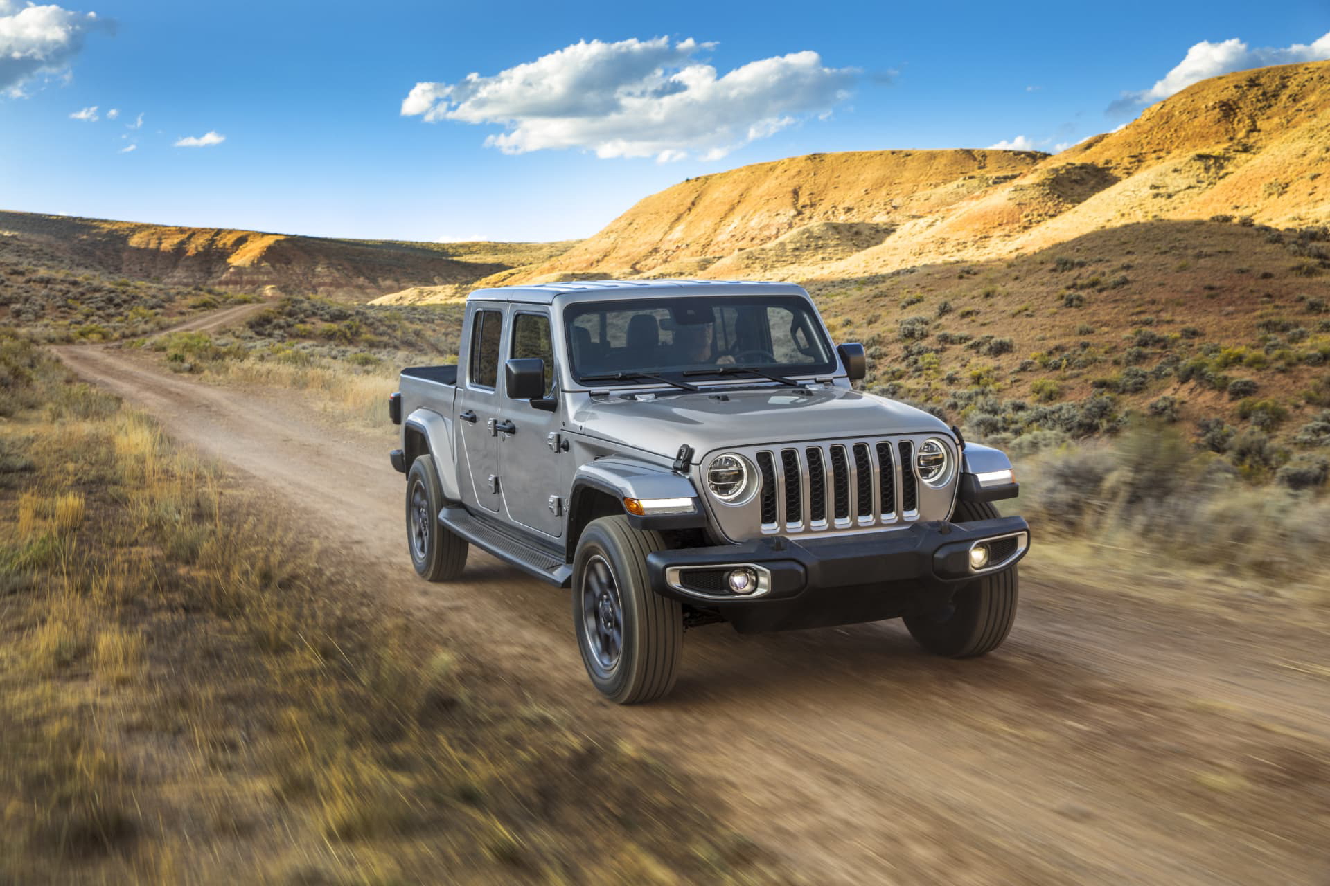 Jeep Gladiator avanzando por terreno rústico, mostrando su capacidad todoterreno.