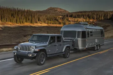 Vista lateral de un Jeep Gladiator remolcando una caravana, mostrando su capacidad de arrastre.