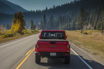 Vista trasera y lateral del Jeep Gladiator rodando por carretera asfaltada.