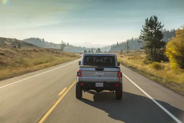 Vista trasera del Jeep Gladiator en carretera abierta, destacando su robustez.