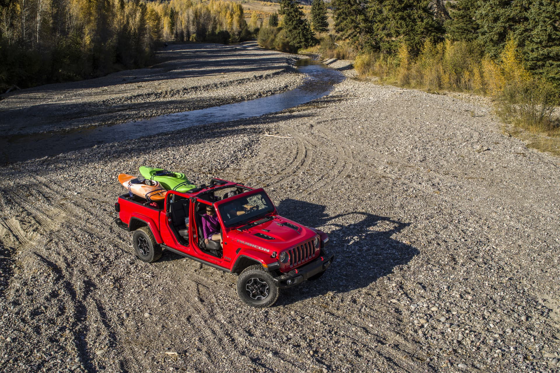 Vista aérea lateral de un Jeep Gladiator en terreno off-road, equipado para la aventura.