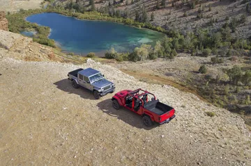 Dos Jeep Gladiator apreciados desde una vista aérea en un entorno natural.