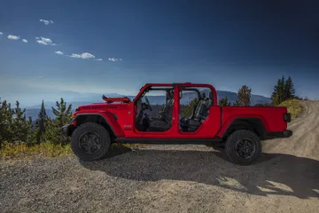 Vista lateral del Jeep Gladiator en un entorno al aire libre, mostrando su perfil robusto.