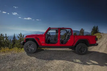 Vista lateral del Jeep Gladiator en entorno de montaña, destacando su perfil robusto.