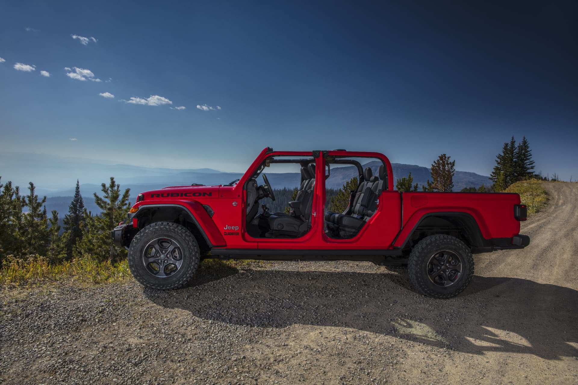 Vista lateral del Jeep Gladiator en entorno de montaña, destacando su perfil robusto.