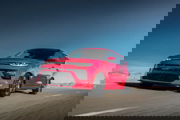 Vista dinámica Kia e-Soul enfatizado contra cielo despejado, ideal para apreciar su diseño.
