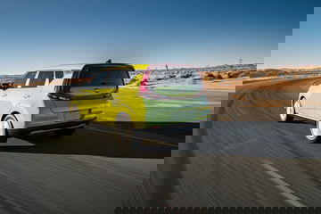 Vista dinámica lateral del Kia e-Soul en movimiento, resaltando su diseño futurista.
