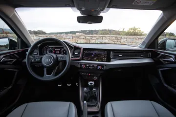 Vista frontal del habitáculo, destacando el volante y consola central del Audi A1.