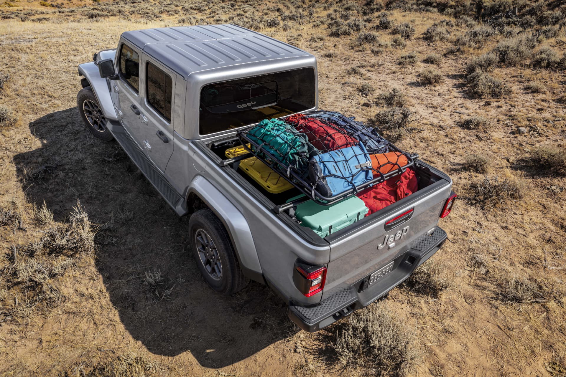Vista aérea del Jeep Gladiator con equipaje en la batea, mostrando su funcionalidad y espacio.