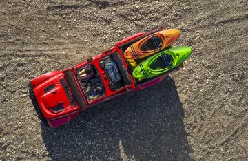 Jeep Gladiator con kayak en la zona de carga, vista aérea destacando su funcionalidad.