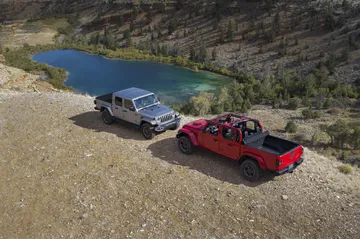 Imágenes aéreas de dos Jeep Gladiator aparcados junto a un lago de montaña.