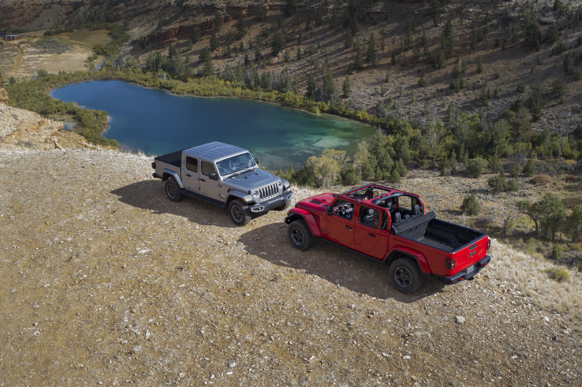 Imágenes aéreas de dos Jeep Gladiator aparcados junto a un lago de montaña.
