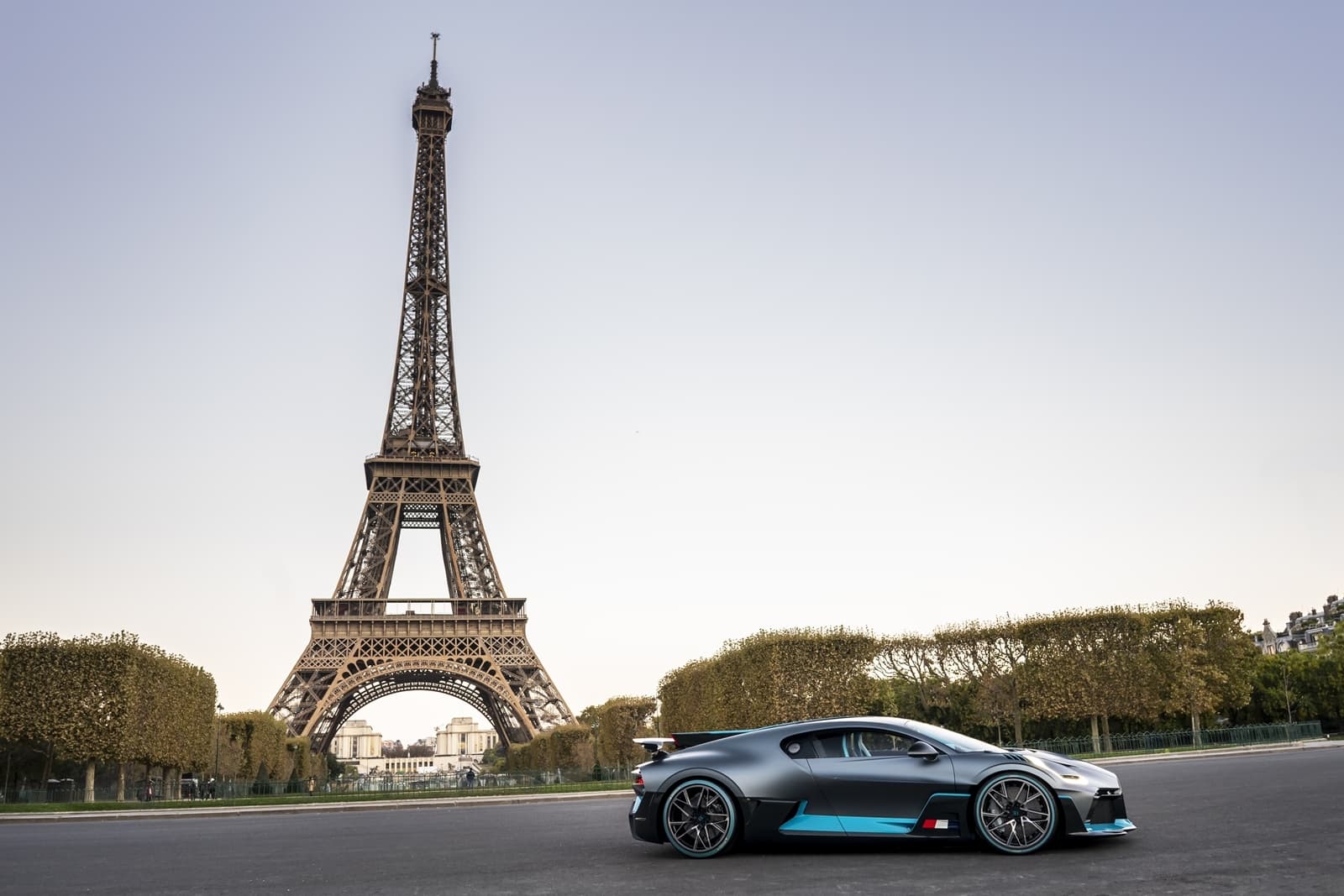 Vista frontal y lateral del Bugatti Divo junto a la Torre Eiffel, destacando su diseño aerodinámico.