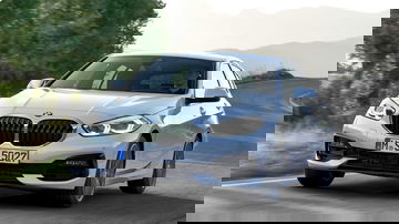 Vista dinámica BMW Serie 1 en carretera, destacando su frontal icónico.