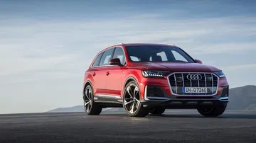 Vista dinámica del Audi Q7 destacando su poderoso frontal y diseño lateral.