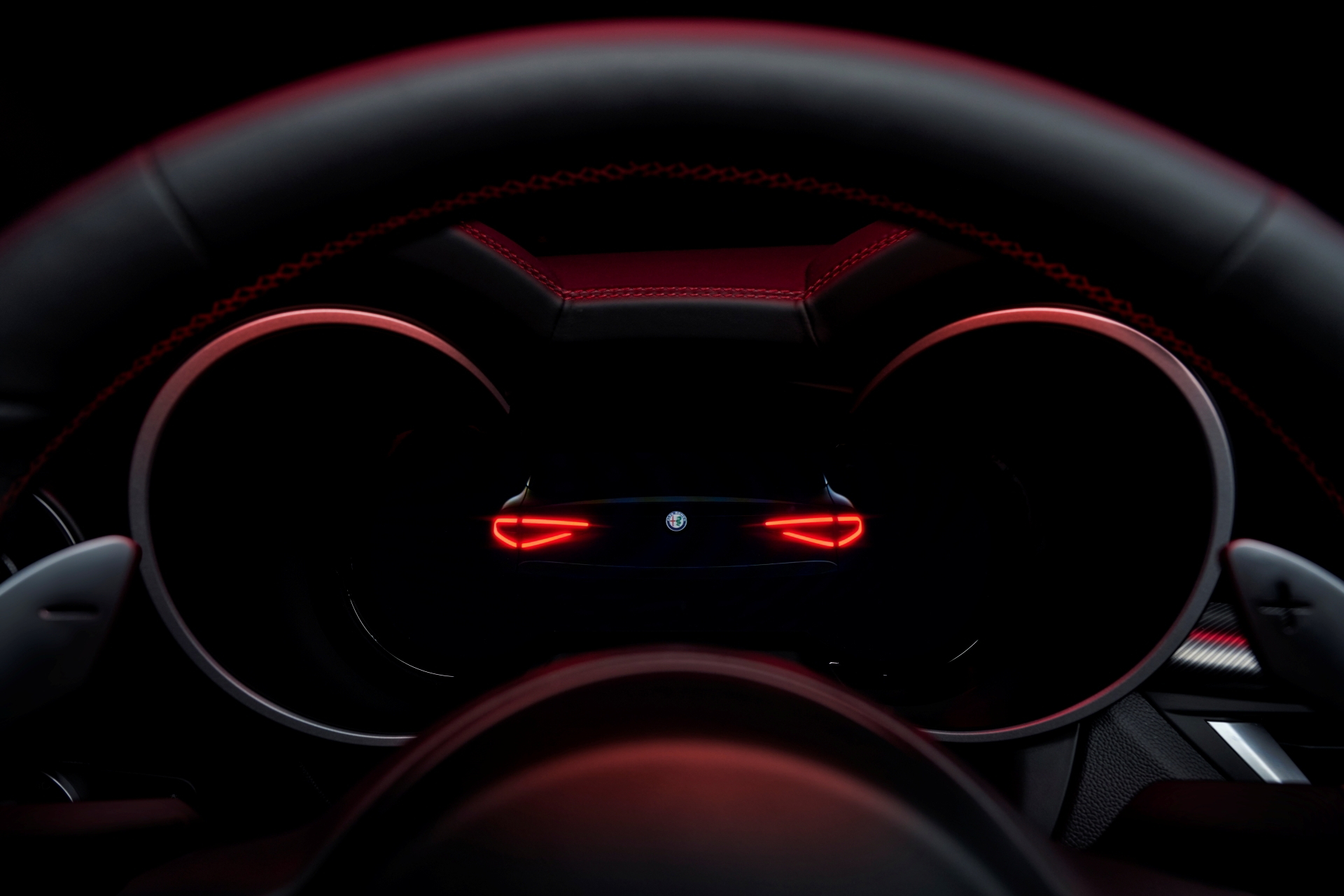 Volante deportivo con iluminación ambiental roja resaltando su diseño.