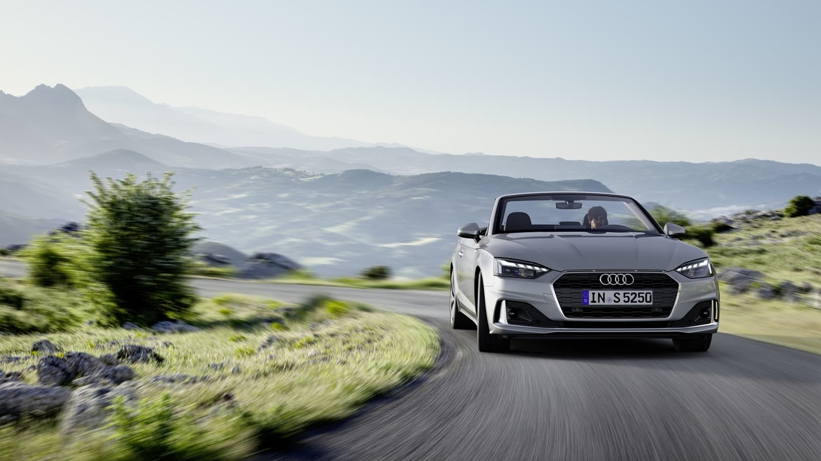 Audi A5 Cabriolet en movimiento, mostrando su diseño frontal y lateral.