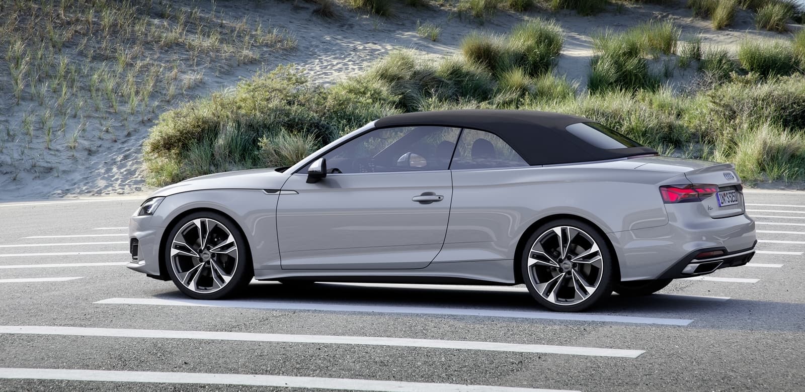 Vista lateral del Audi A5 Cabriolet en movimiento, destacando su silueta aerodinámica.