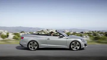 Vista dinámica del Audi A5 Cabriolet con capota baja, reflejando elegancia y deportividad.