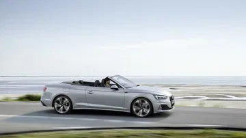 Elegante perfil lateral del Audi A5 Cabriolet con el techo replegado.