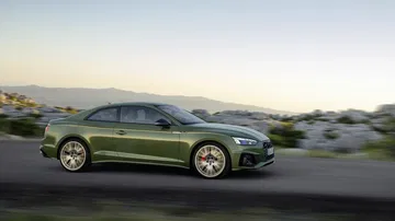 Vista en movimiento lateral del Audi A5 Coupé, resaltando su diseño aerodinámico.