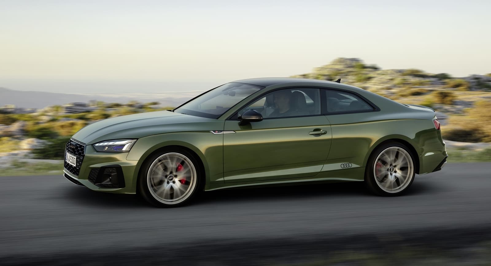 Perfil lateral de un Audi A5 en movimiento demostrando su dinamismo y líneas elegantes.
