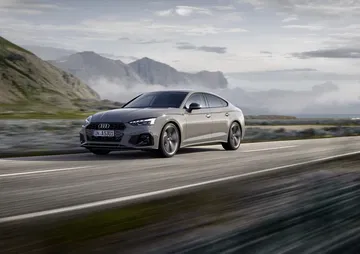 Vista dinámica del Audi A5 Sportback en carretera, destacando su silueta aerodinámica.