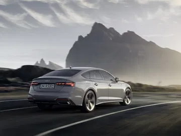 Vista lateral y posterior del Audi A5 Sportback en movimiento, destacando su silueta deportiva.