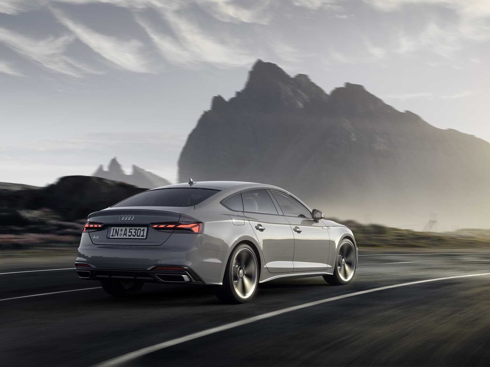 Vista lateral y posterior del Audi A5 Sportback en movimiento, destacando su silueta deportiva.