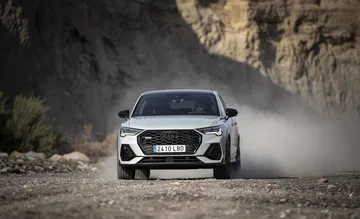 Vista frontal del Audi Q3 Sportback en movimiento, mostrando su robustez y dinamismo.