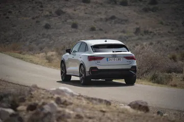 Vista dinámica del Audi Q3 Sportback mostrando su línea lateral y trasera.