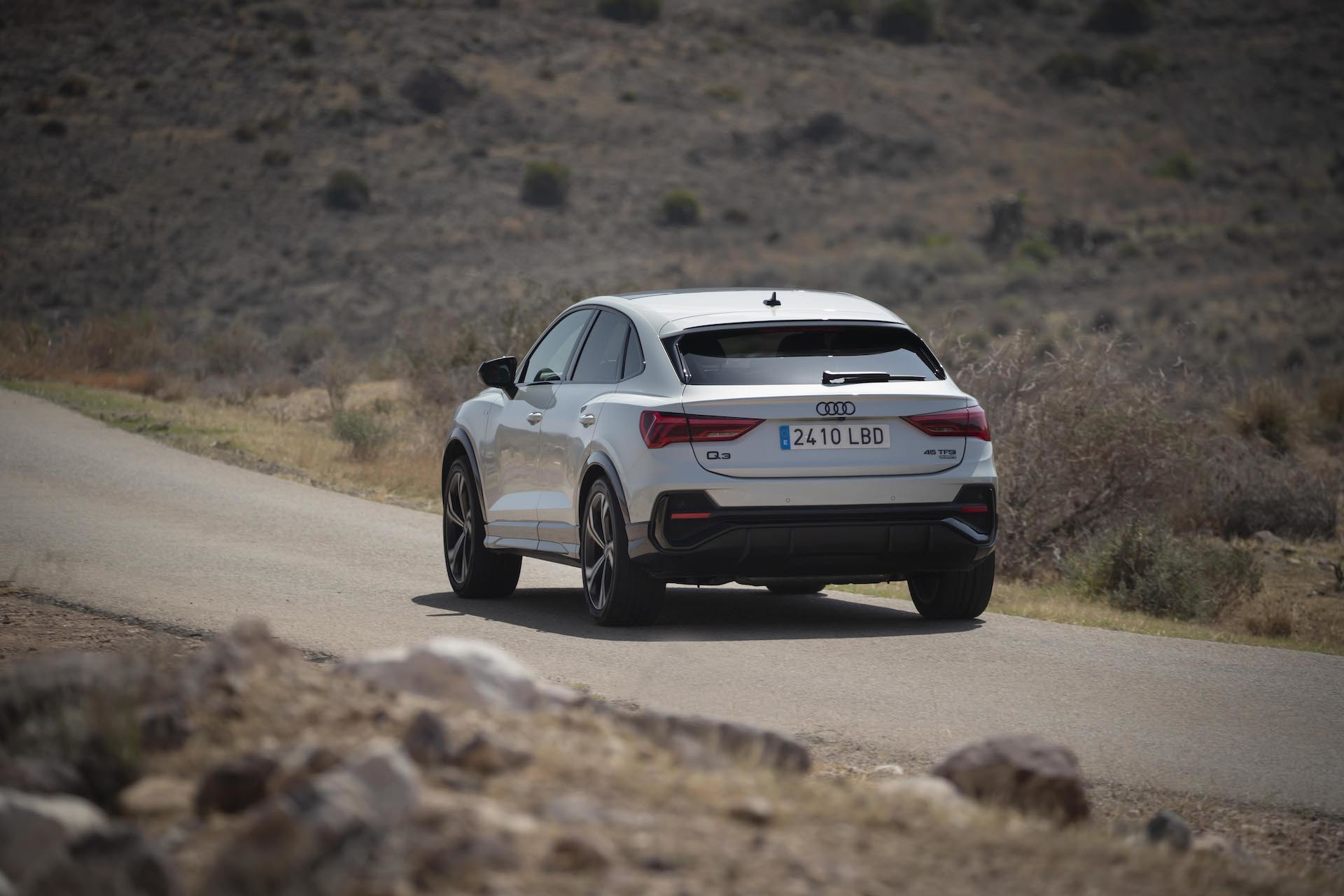 Vista dinámica del Audi Q3 Sportback mostrando su línea lateral y trasera.