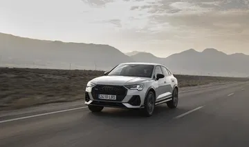 Vista dinámica del Audi Q3 Sportback en carretera, destacando su diseño frontal y lateral.