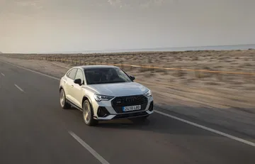 Vista lateral del Audi Q3 Sportback en movimiento, destacando su diseño y aerodinámica.