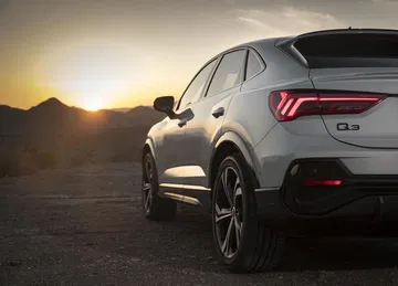 Vista posterior lateral Audi Q3 Sportback al atardecer.