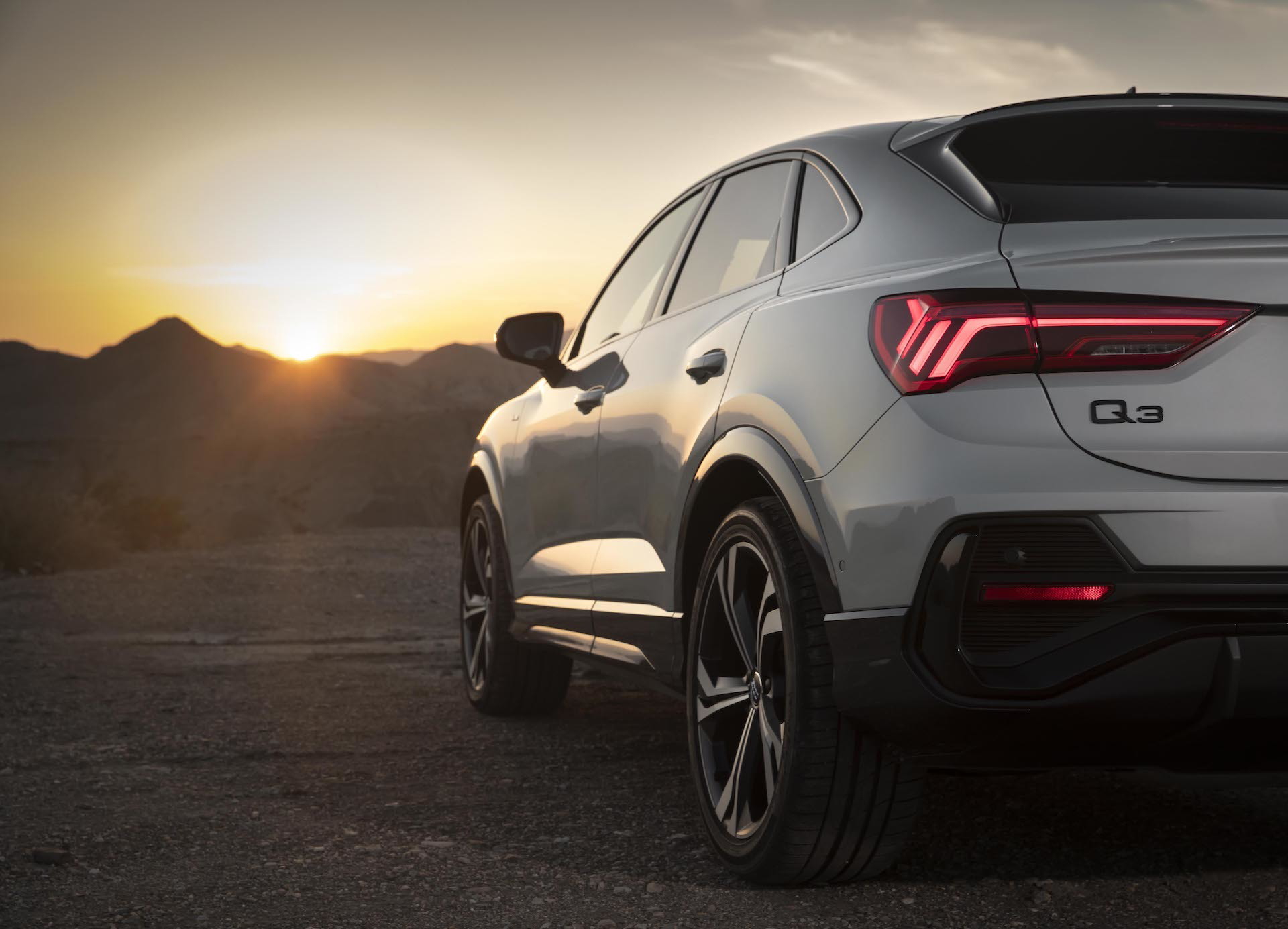 Vista posterior lateral Audi Q3 Sportback al atardecer.