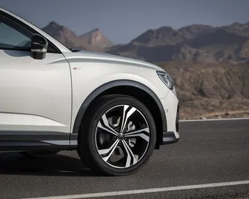 Vista lateral detallada muestrando diseño llantas y carrocería.