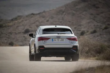 Vista trasera del Audi Q3 Sportback en carretera, destacando diseño y luces LED.