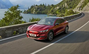 Vista dinámica del Ford Mustang Mach-E en carretera, destacando su diseño frontal.