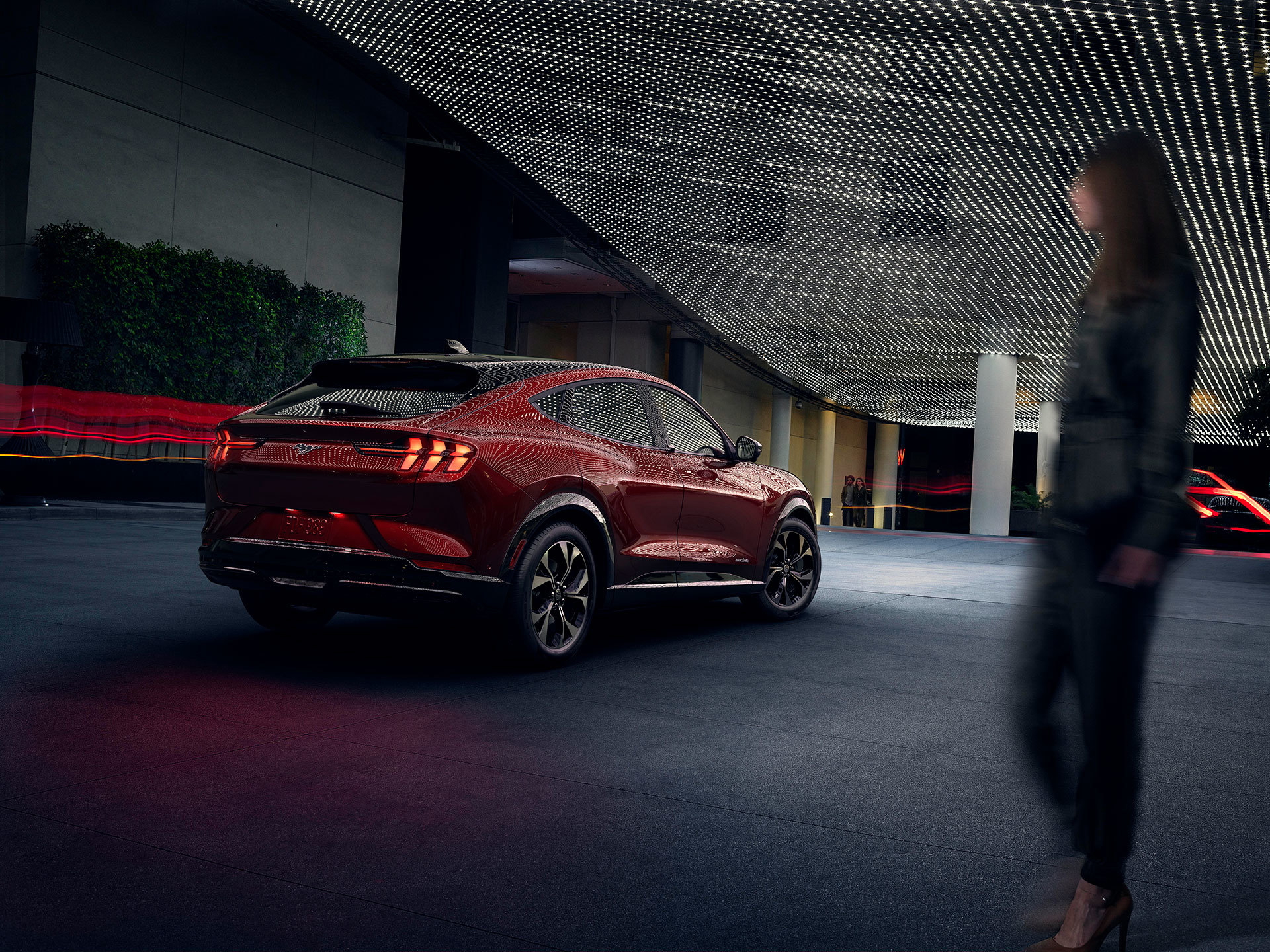 Vista trasera del Ford Mustang Mach-E en un ambiente urbano nocturno.