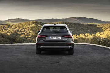 Vista trasera del Audi A3 Sportback 2020 en gris Daytona, mostrando su diseño y faros.