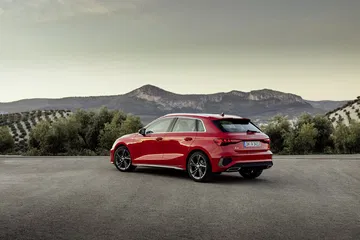 Audi A3 Sportback 2020 en rojo tango, vista trasera y lateral en carretera.