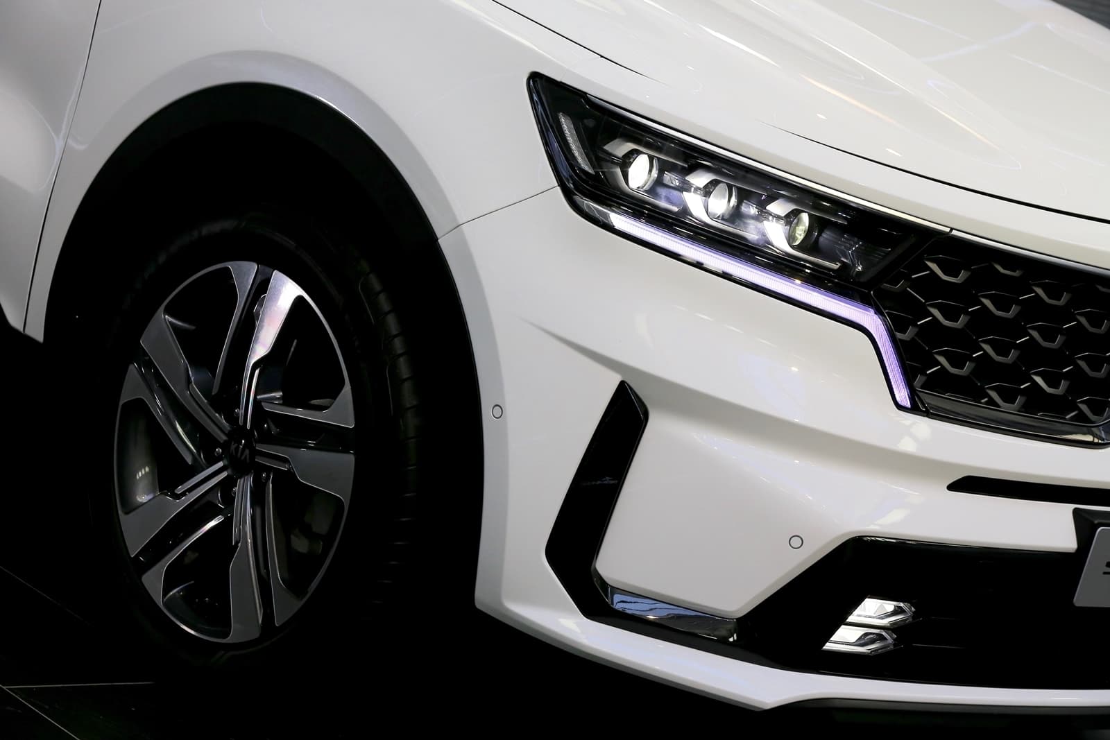 Visión cercana de llanta y faros delanteros del Kia Sorento.