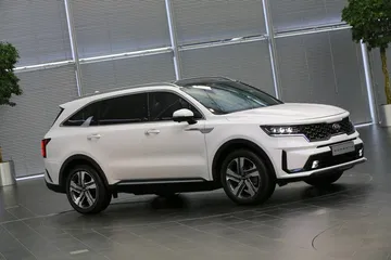 Vista lateral del Kia Sorento en movimiento, destacando su diseño robusto y moderno.