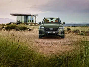 Vista frontal del Audi Q5 en un entorno rural destacando su parrilla y faros.