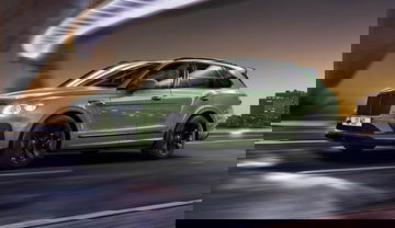 Bentayga exhibiendo su perfil lateral en tono verde exclusivo y rines negros.
