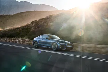 BMW Serie 4 en conducción lateral con puesta de sol al fondo.