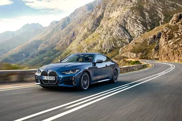 BMW Serie 4 luciendo su estilizada silueta en carretera montañosa.
